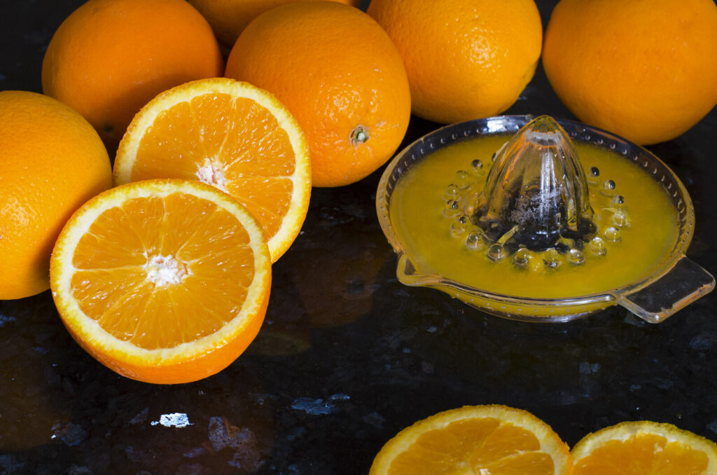 citrus juicer with oranges around it