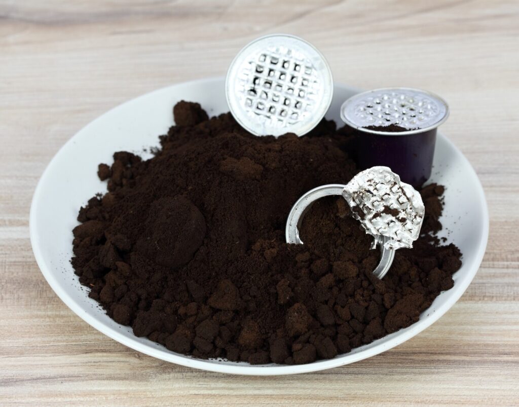 on a wooden surface is a white dish with coffee grounds