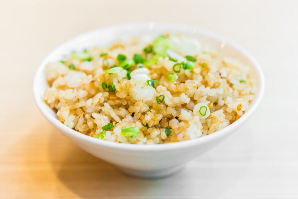 a bowl of garlic fried rice on a wooden table