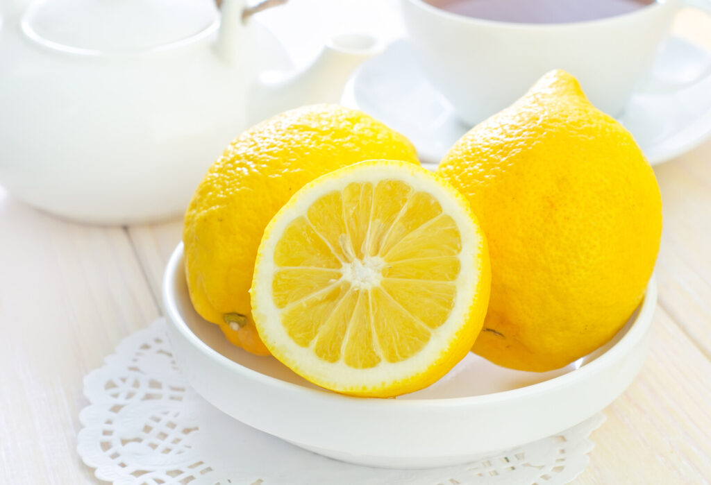 closeup image of a white dish with a couple of whole lemon and one cut in half