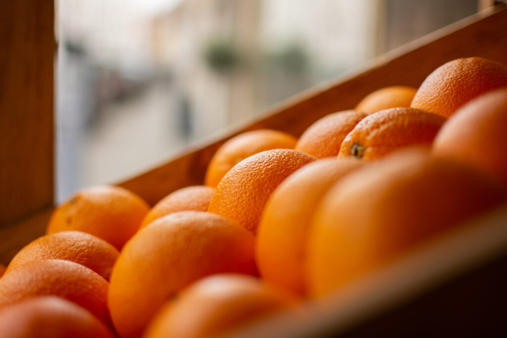 closeup image of a wooden crate full of oranges