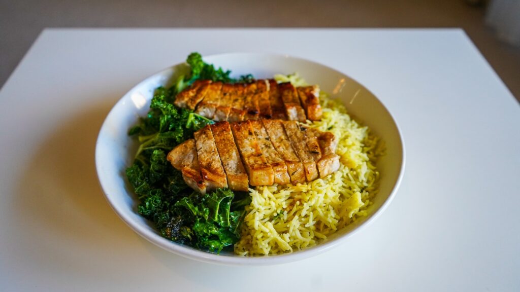 yellow rice with steamed veggies and fried pork chops