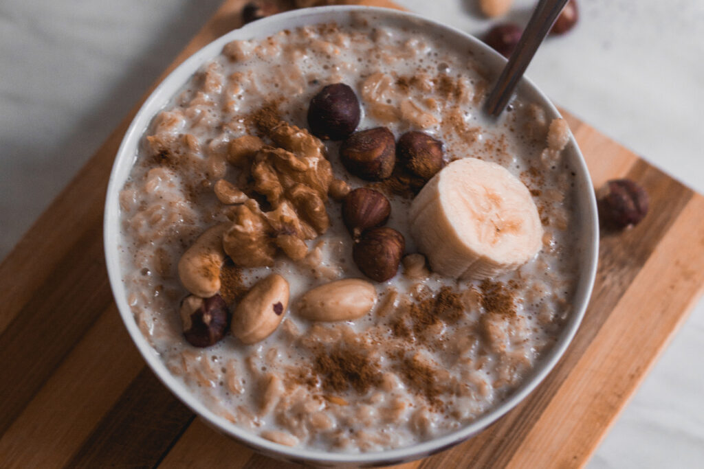 a bowl of chocolatey oatmeal with banana and nuts toppings, representing the article "Easy To Cook Breakfast To Start Your Day" by My Kitchendom