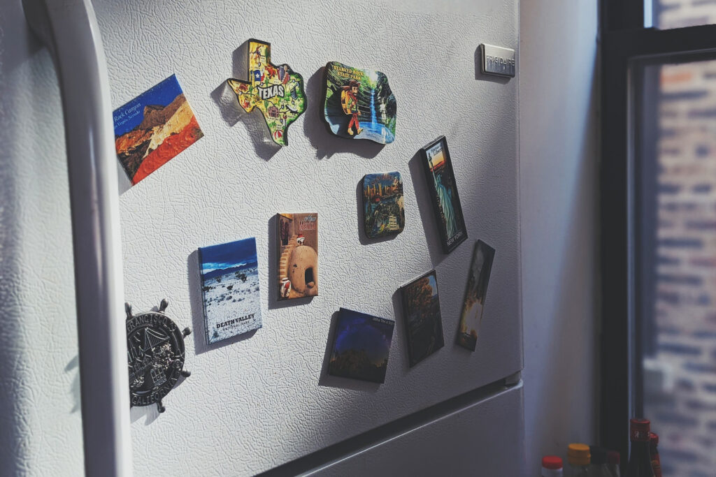 a closeup image of a fridge's freezer door with fridge magnets attached