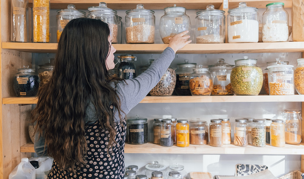 woman organizing her pantry, representing the article "No Pantry, No Problem: How To Organize a Small Kitchen Without a Pantry" by My Kitchendom