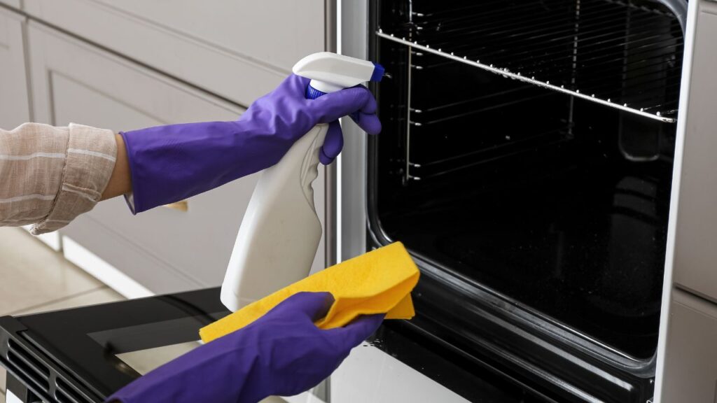 cleaning oven with white vinegar, representing the article "The Best Way To Clean Your Oven" by My Kitchendom