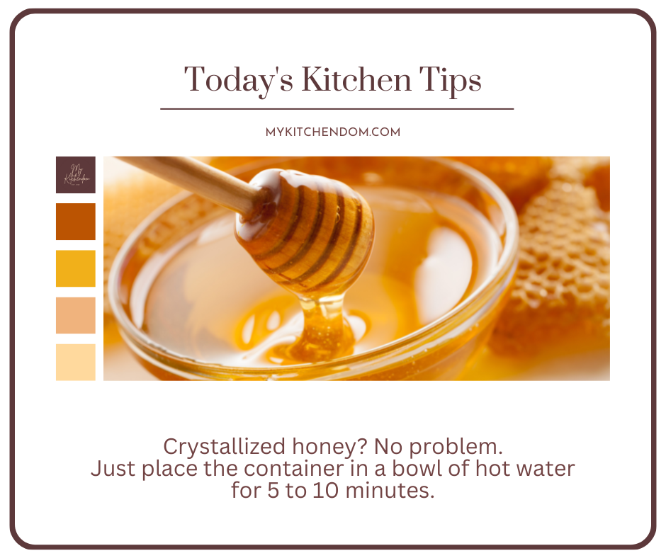 a clear glass bowl of honey with a wooden honey dipper