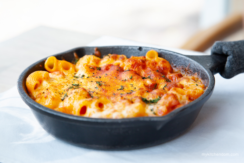 baked macaroni in a small iron skillet